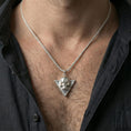 Load image into Gallery viewer, Polished silver Absolute’s talisman skull necklace worn on neck, BG3 fan pendant on braided chain, clean close-up
