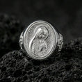 Load image into Gallery viewer, Polished silver Our Lady of Guadalupe oval signet ring on porous volcanic stone, reflective Catholic ring, studio detail
