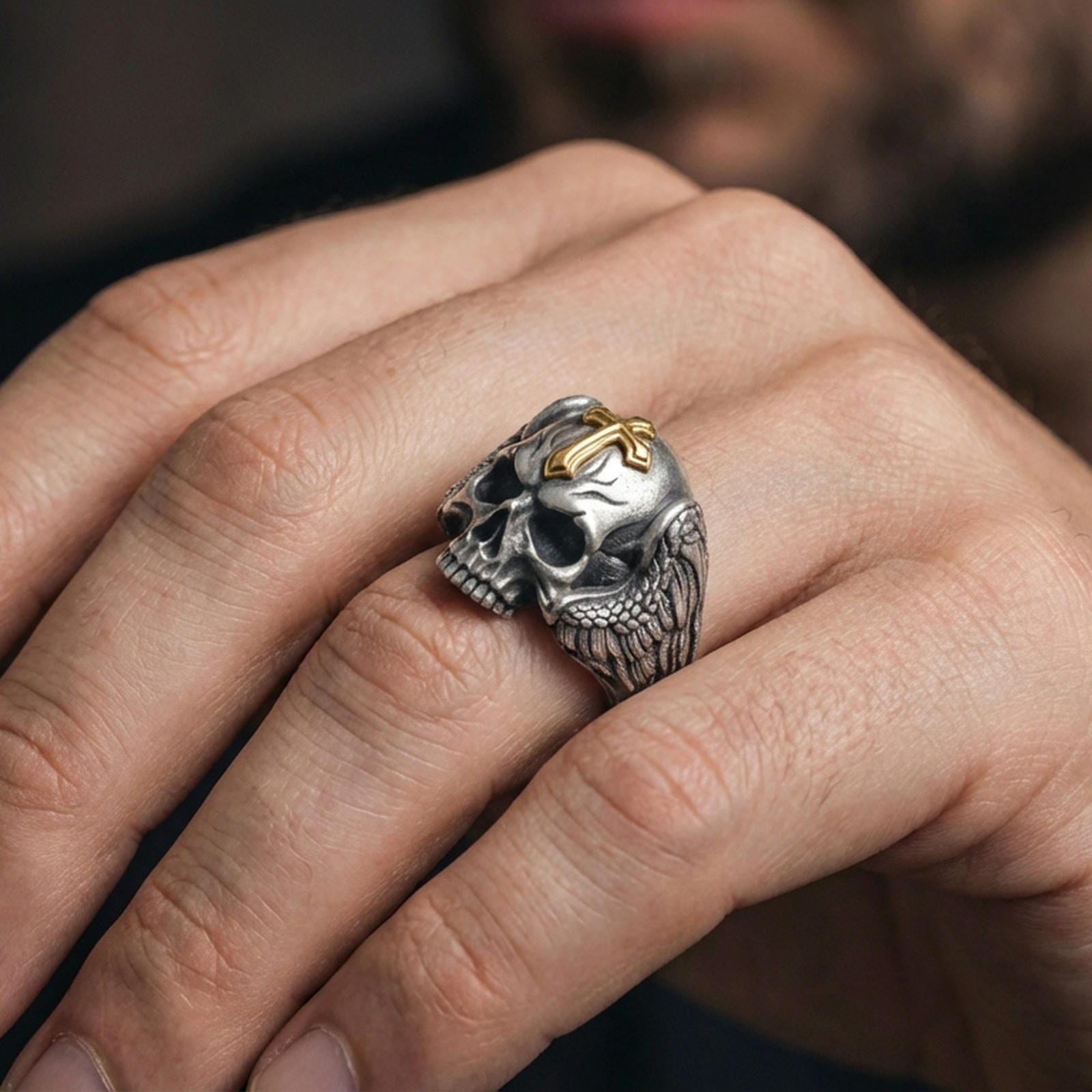 Oxidized sterling silver skull ring with cross worn on finger, winged gothic biker ring, memento mori style close-up