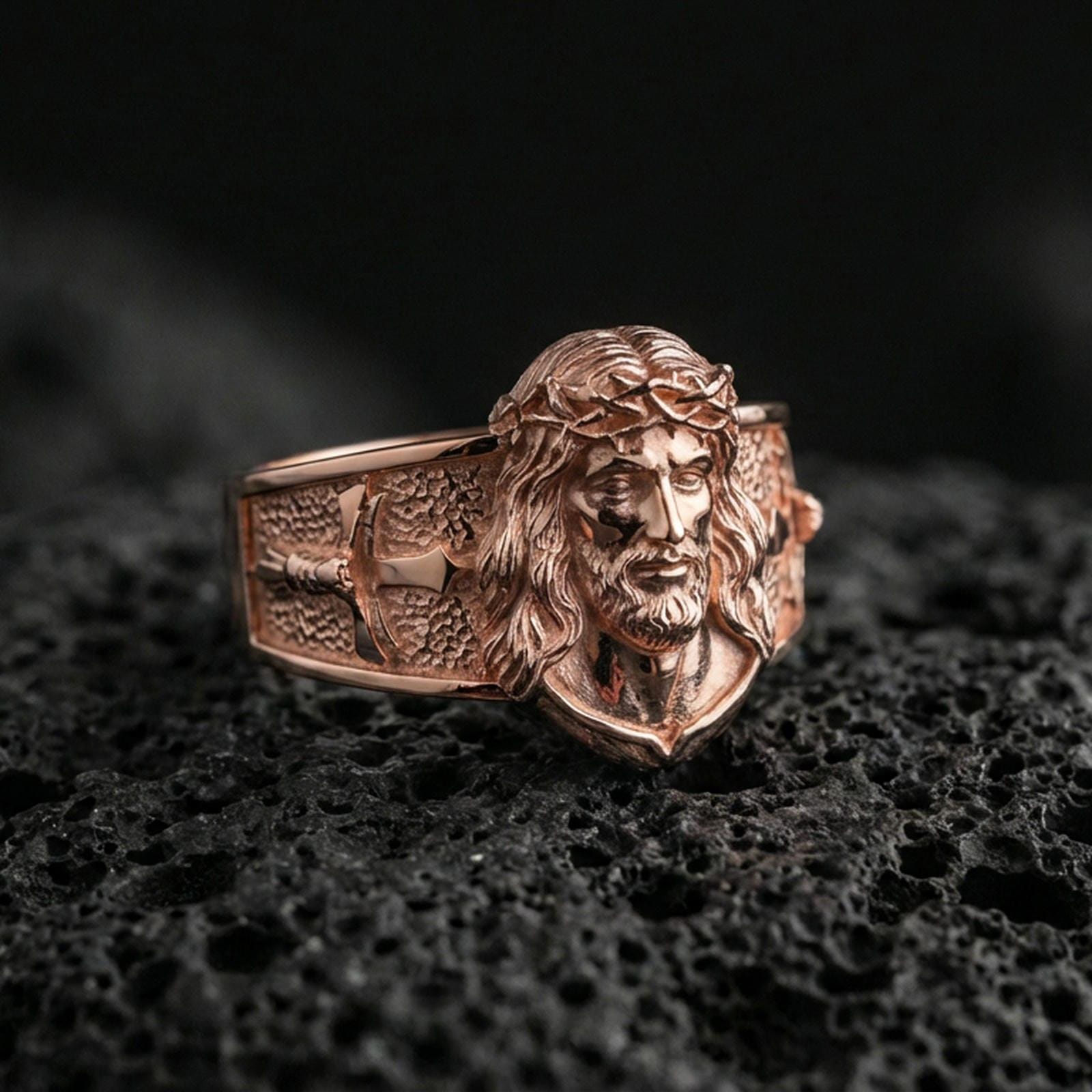 Rose gold plated Jesus Christ ring on volcanic stone, Christ face relief ring, Christian signet style ring macro shot