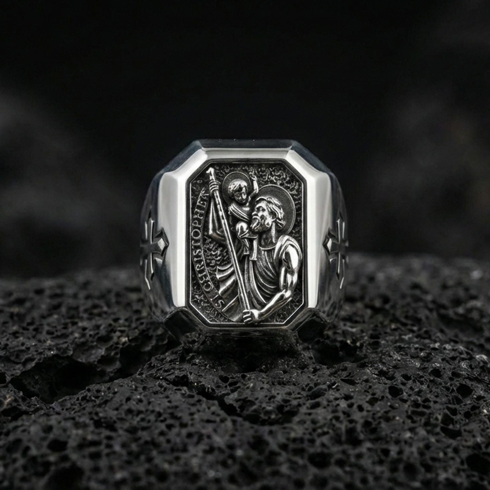Polished silver St Christopher ring on porous volcanic stone, detailed saint engraving with staff, Catholic signet macro