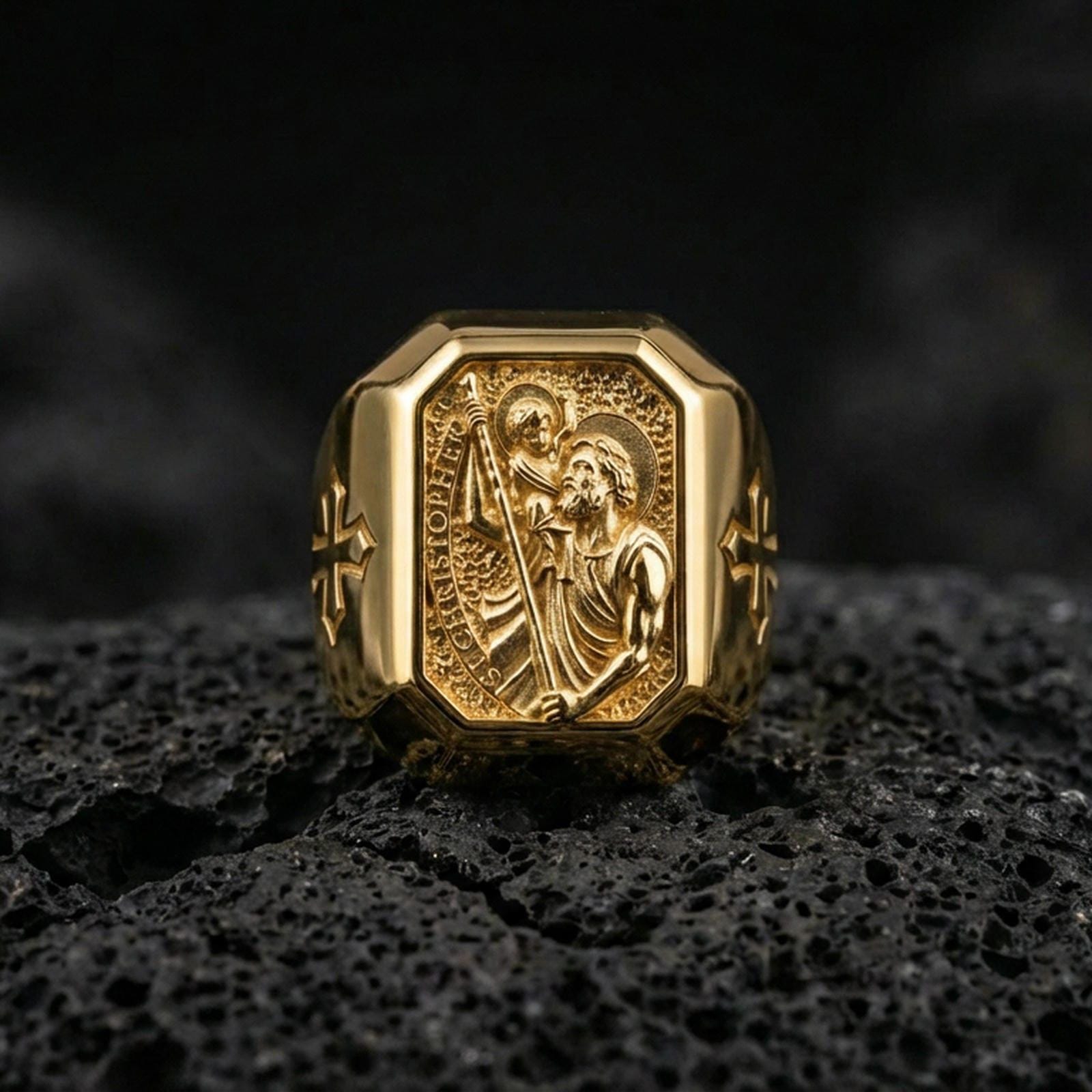 Gold plated St Christopher signet ring on dark volcanic rock, patron saint of travelers ring, cross side motif close-up