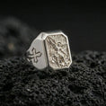 Load image into Gallery viewer, Polished silver Saint Michael ring on porous volcanic stone, angel defeating dragon engraving, Templar cross detail

