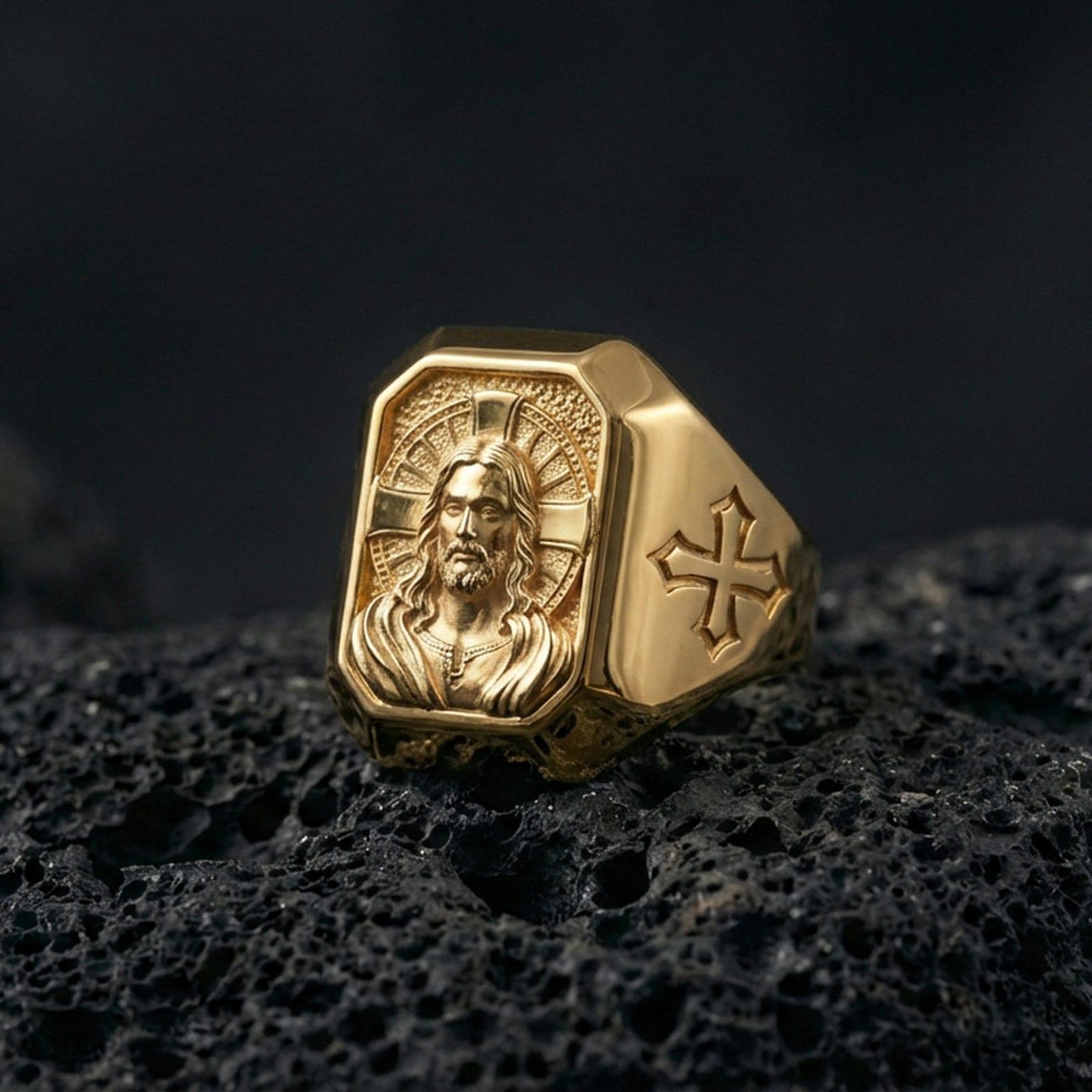Gold plated Jesus Christ signet ring on dark volcanic rock, halo portrait relief, cross side accents
