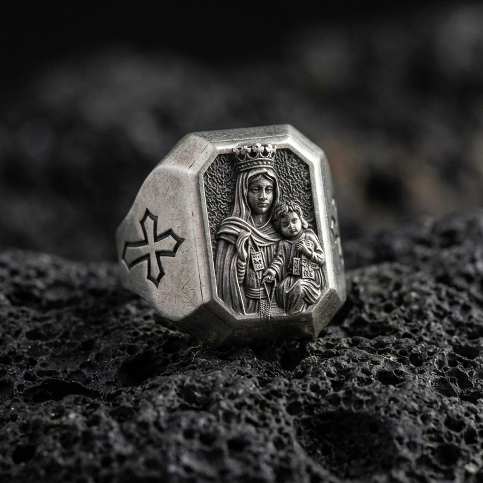 Oxidized sterling silver Virgin Mary ring on volcanic rock, crowned Madonna and Child relief, cross shoulder engraving close-up