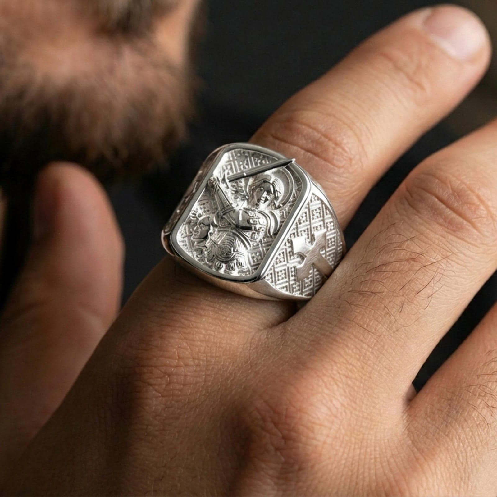 Polished silver Saint Michael signet ring worn on finger, sword and shield archangel engraving, mens religious ring