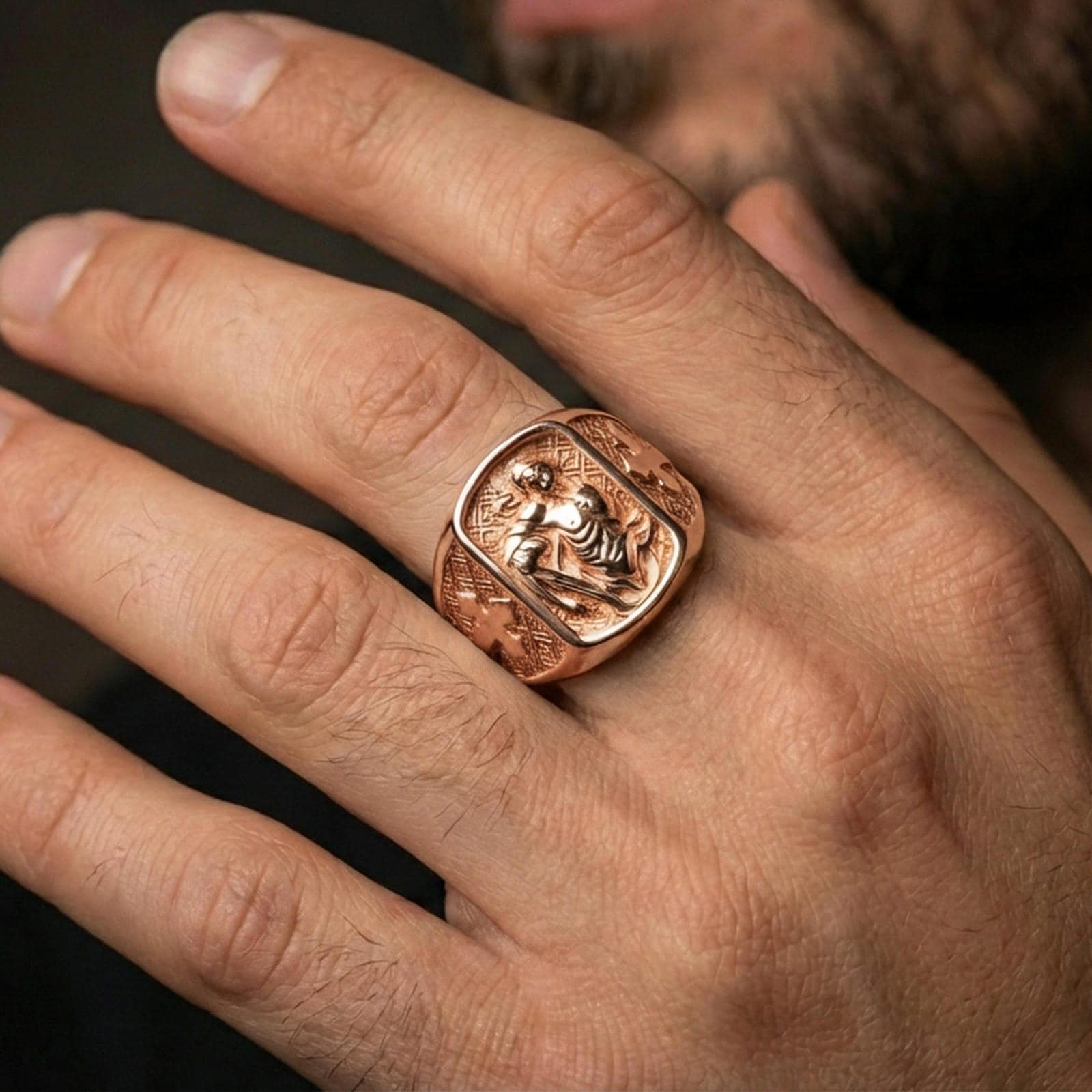 Rose gold plated St Sebastian signet ring worn on finger, saint Sebastian relief with cross shoulders, faith jewelry band