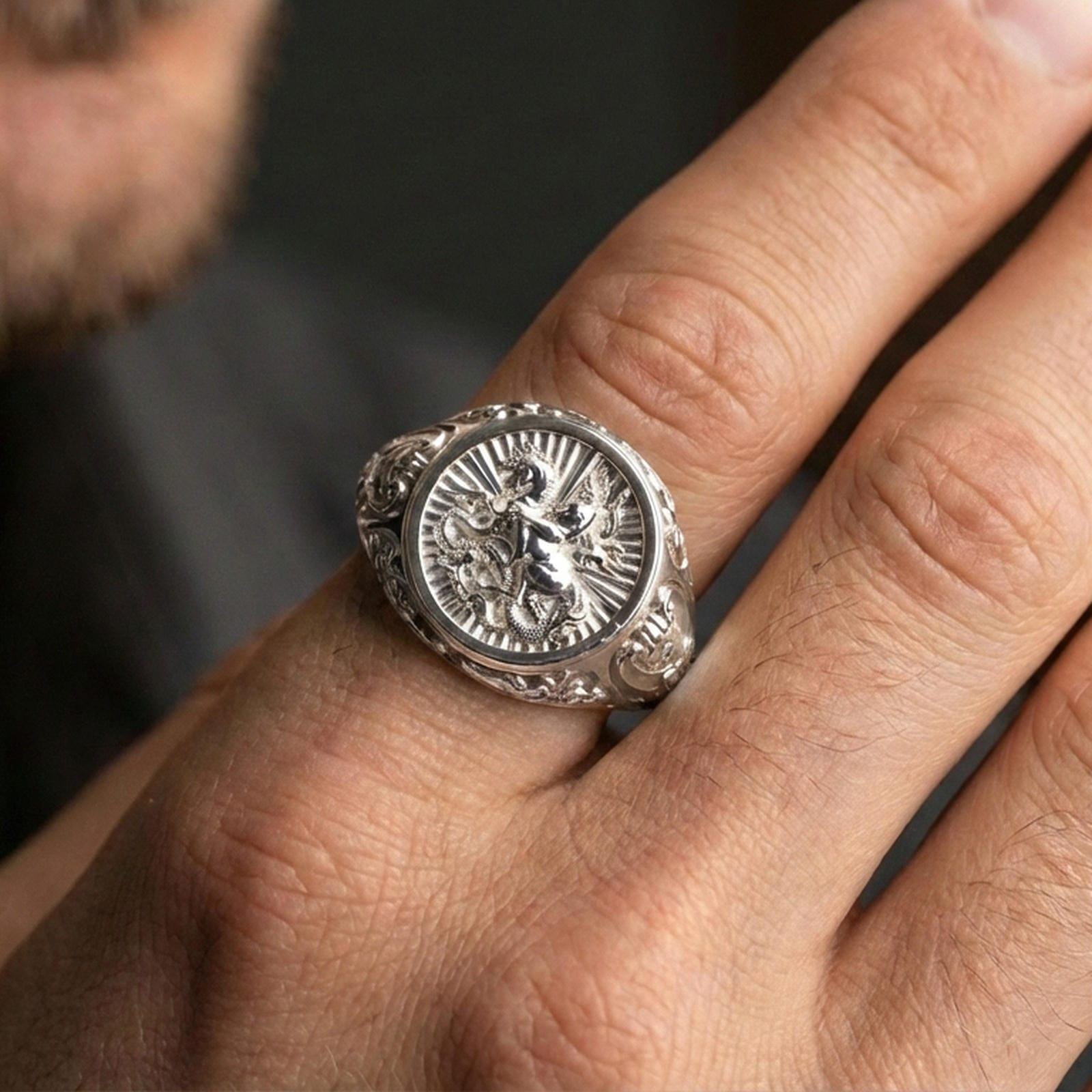 Polished silver St George ring worn on finger, warrior saint engraving, meaningful religious signet ring for men
