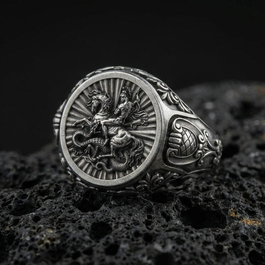 Oxidized sterling silver St George signet ring on volcanic rock, saint slaying dragon relief, Christian protector ring