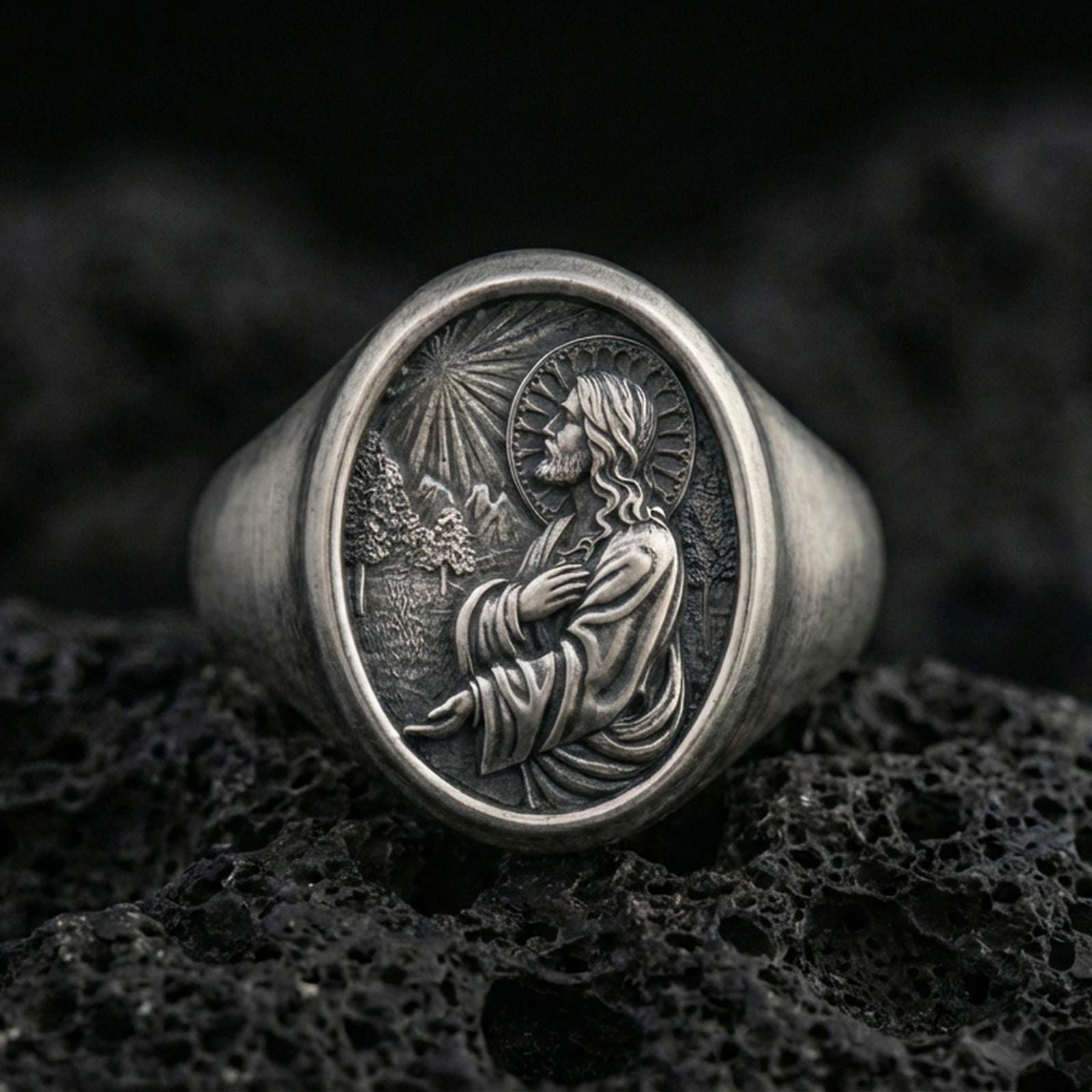 Oxidized 925 sterling silver Jesus Christ signet ring on volcanic rock, halo prayer relief