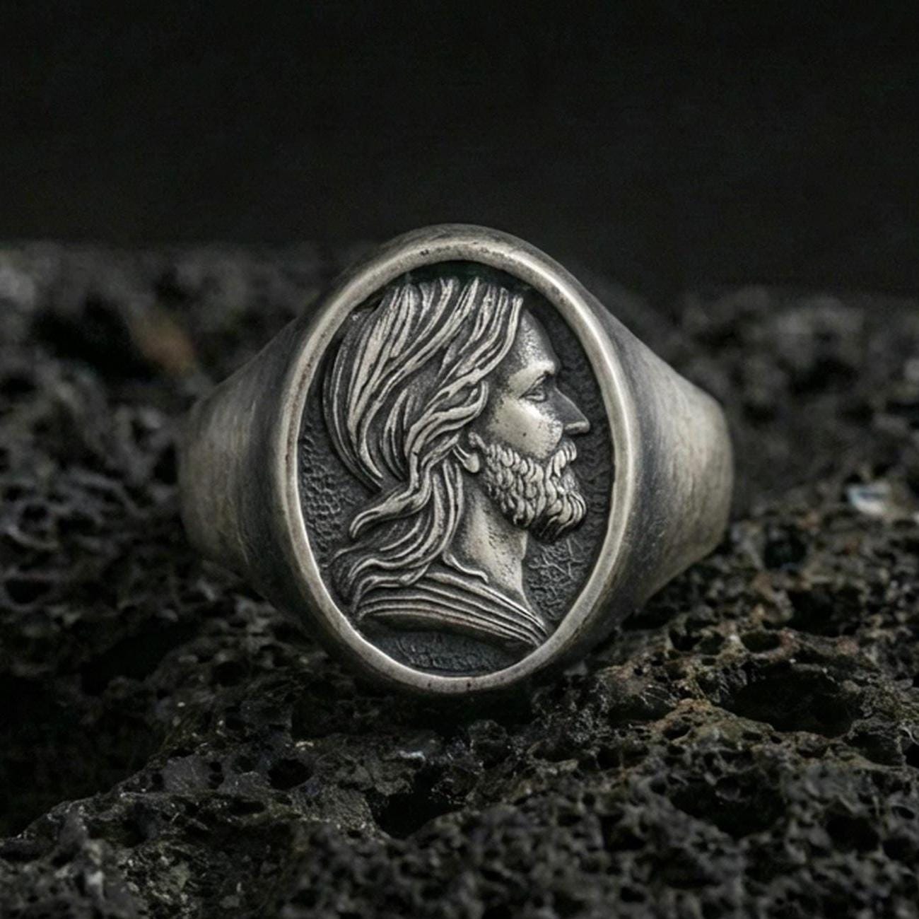 Oxidized sterling silver Jesus signet ring on volcanic rock, Christ portrait side profile relief