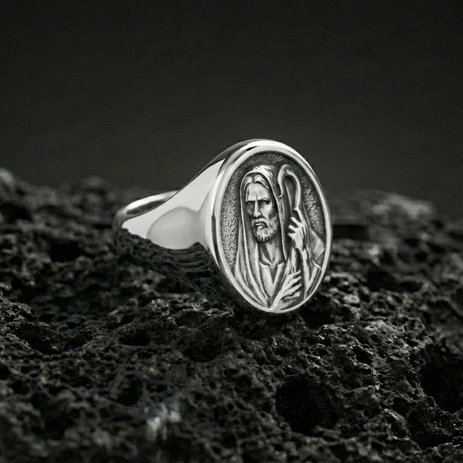 Polished silver Jesus Shepherd ring on porous volcanic stone, detailed shepherd staff engraving, religious signet ring