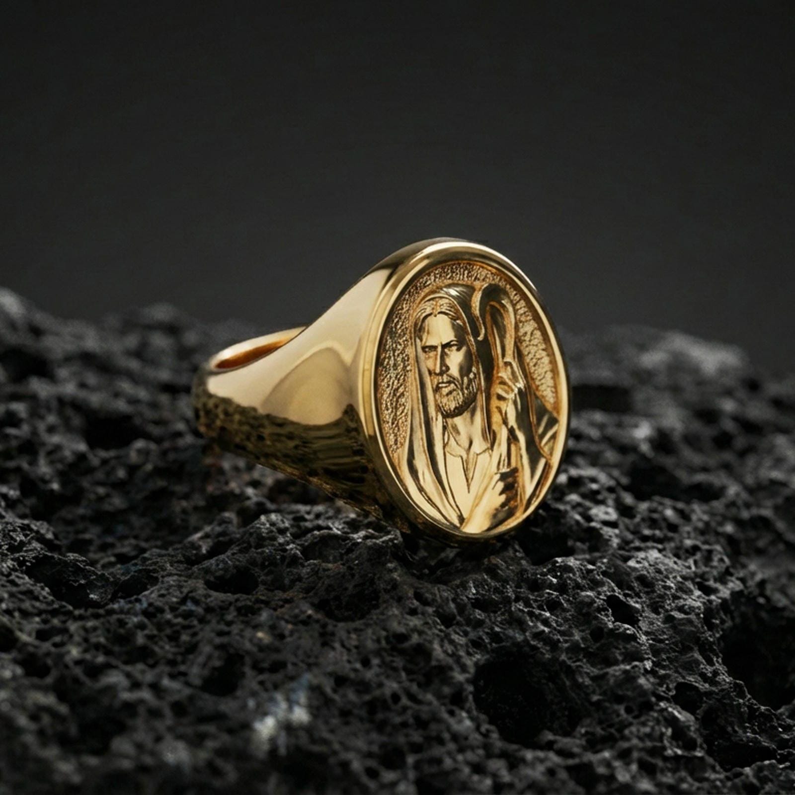 Gold plated Jesus Shepherd signet ring on dark volcanic rock, Christ portrait relief, faith jewelry