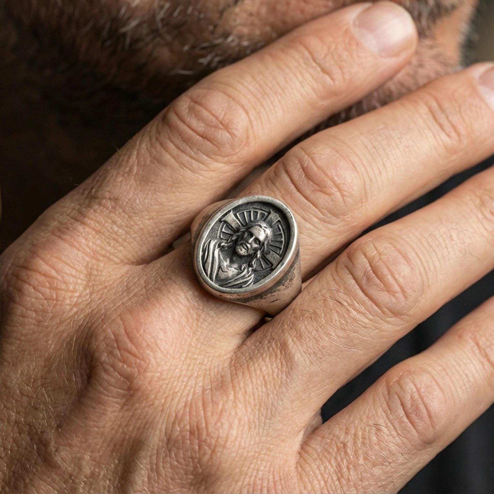 Oxidized 925 sterling silver Jesus Christ signet ring worn on finger, halo cross background, devotional jewelry