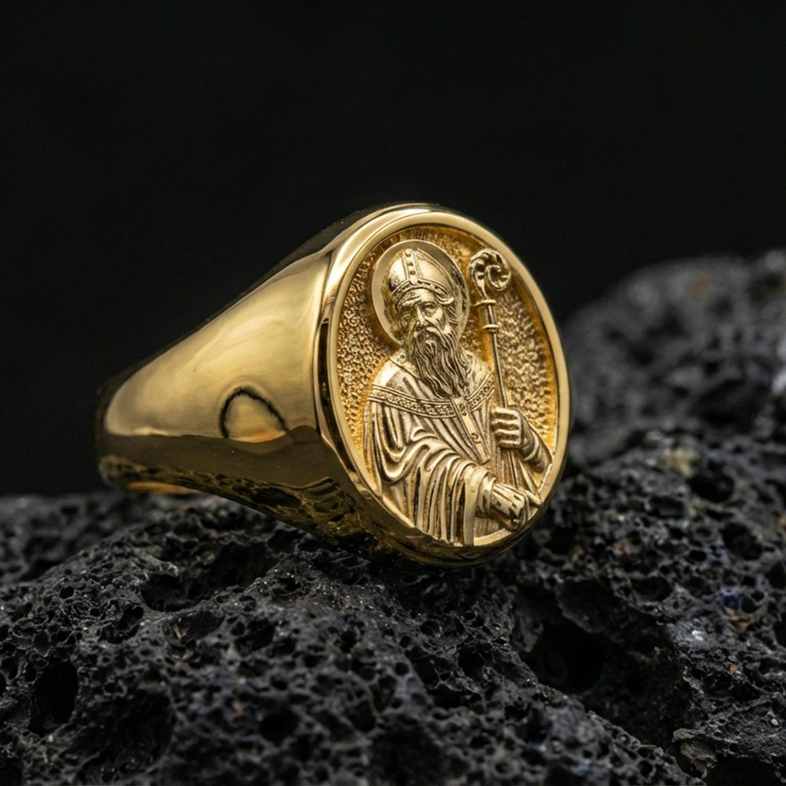 Gold plated Saint Benedict signet ring on dark volcanic rock, holy protector icon relief, Catholic accessory