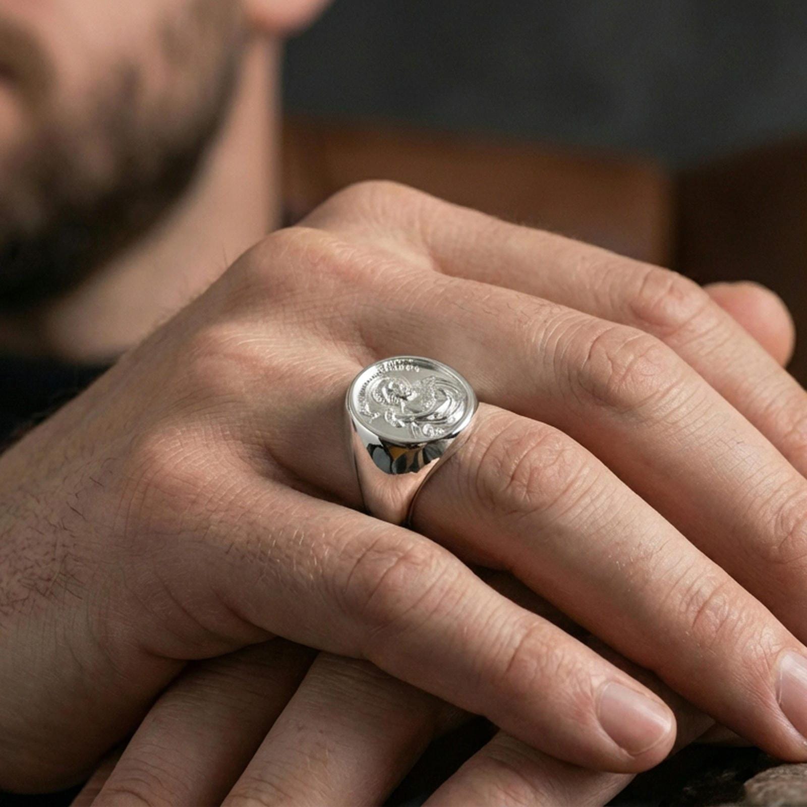 Polished silver Saint John the Baptist signet ring worn on finger, detailed saint engraving, devotional signet style