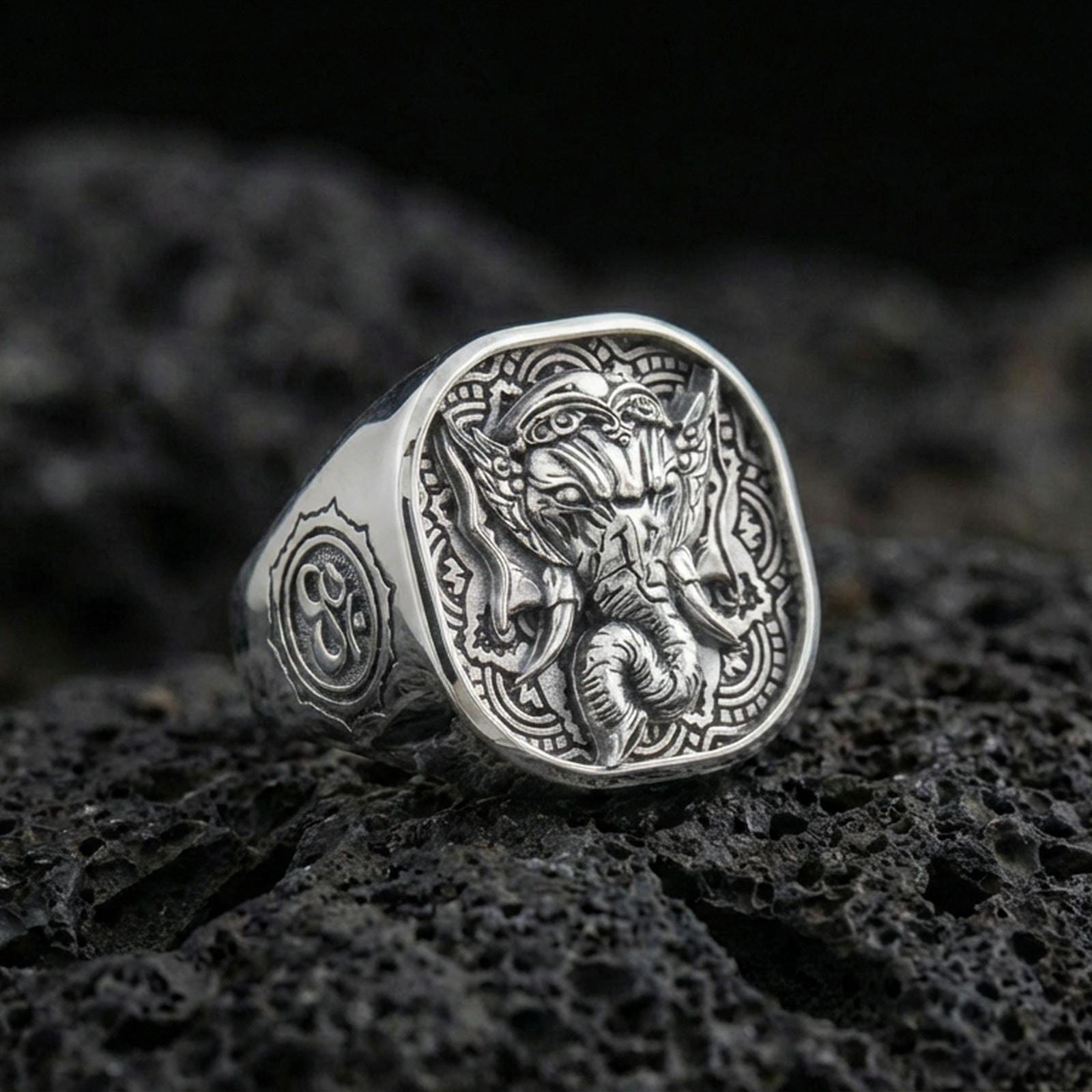 Polished silver Lord Ganesha ring on porous volcanic stone, Indian style engraving, spiritual statement jewelry