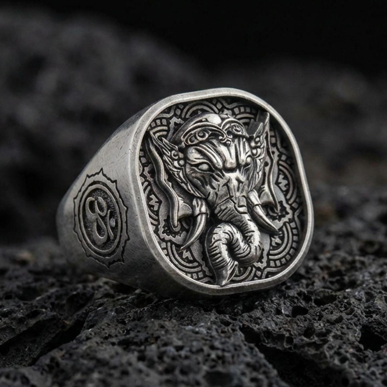 Oxidized 925 sterling silver Lord Ganesha signet ring on volcanic rock, detailed elephant head relief, Hindu amulet