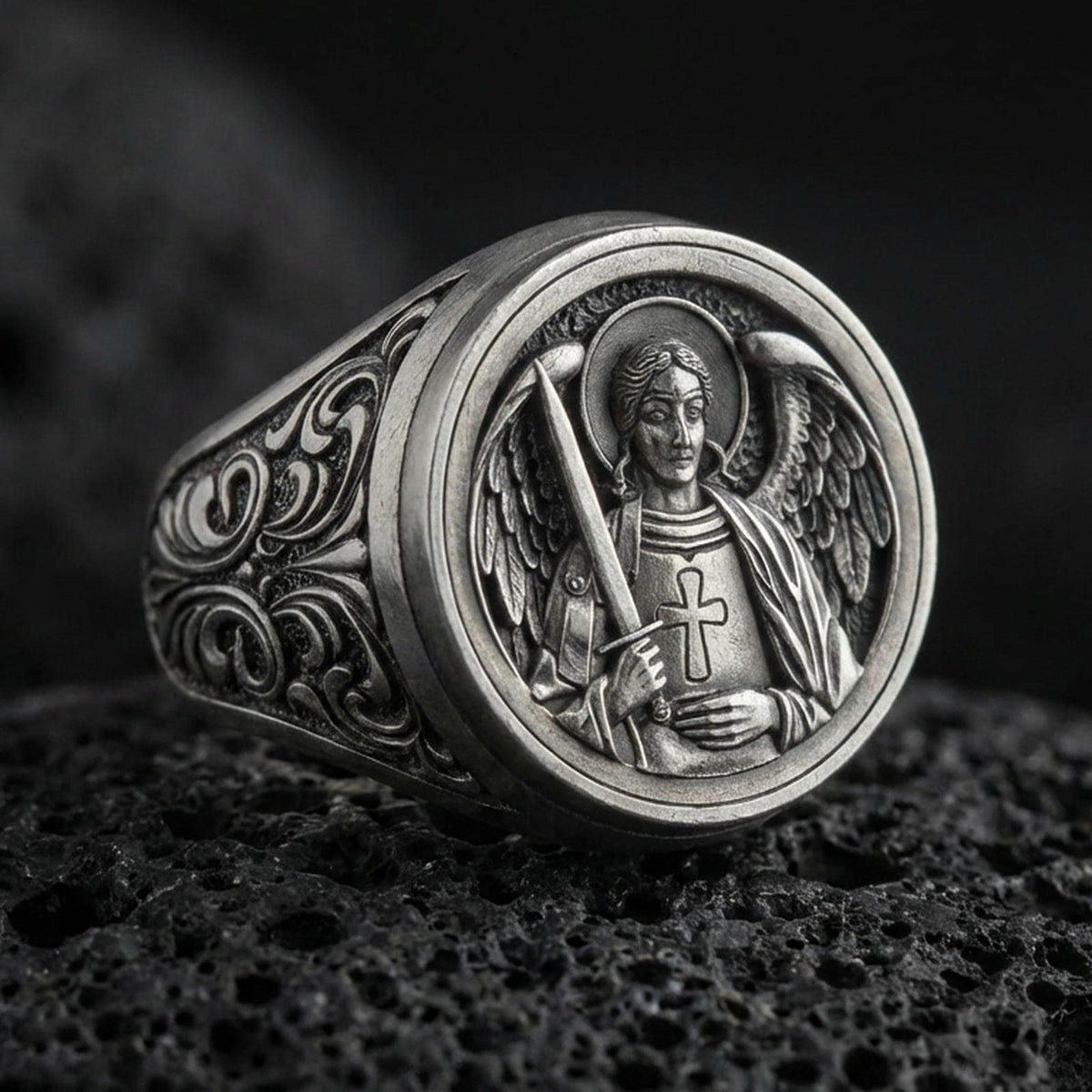 Oxidized 925 sterling silver St Michael archangel ring on volcanic rock, angel wings relief, sword and cross armor