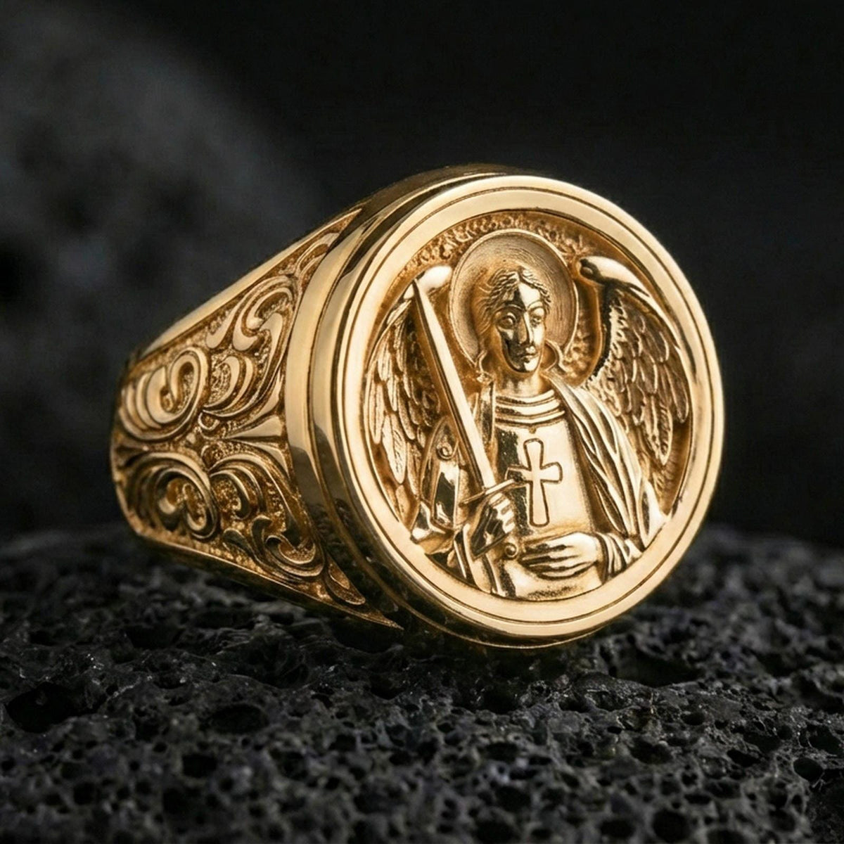 Gold plated sterling silver St Michael archangel ring on dark volcanic rock, angel warrior signet with sword emblem