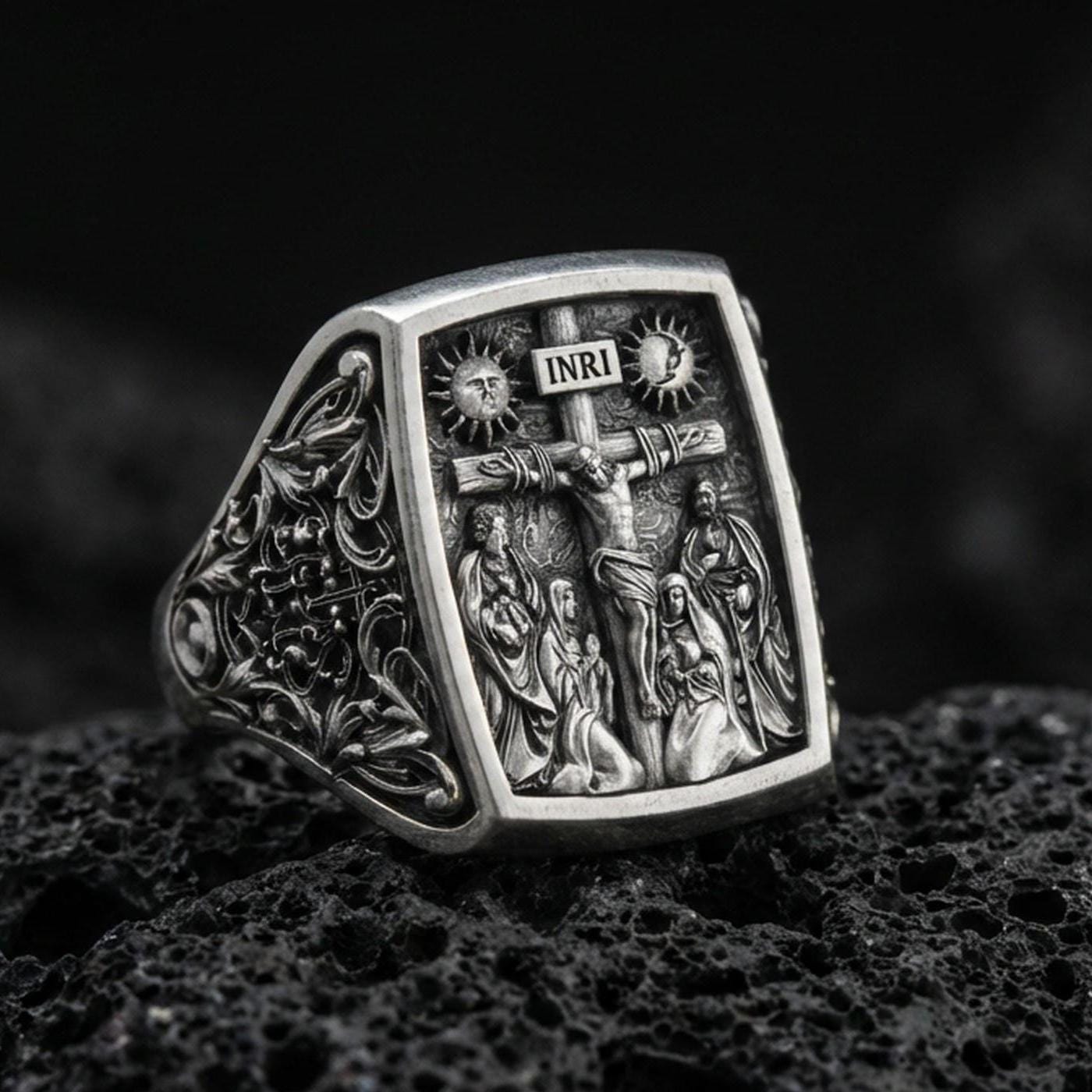 Oxidized 925 sterling silver INRI crucifix signet ring on volcanic rock, detailed Jesus on cross relief, cathedral-style engraving