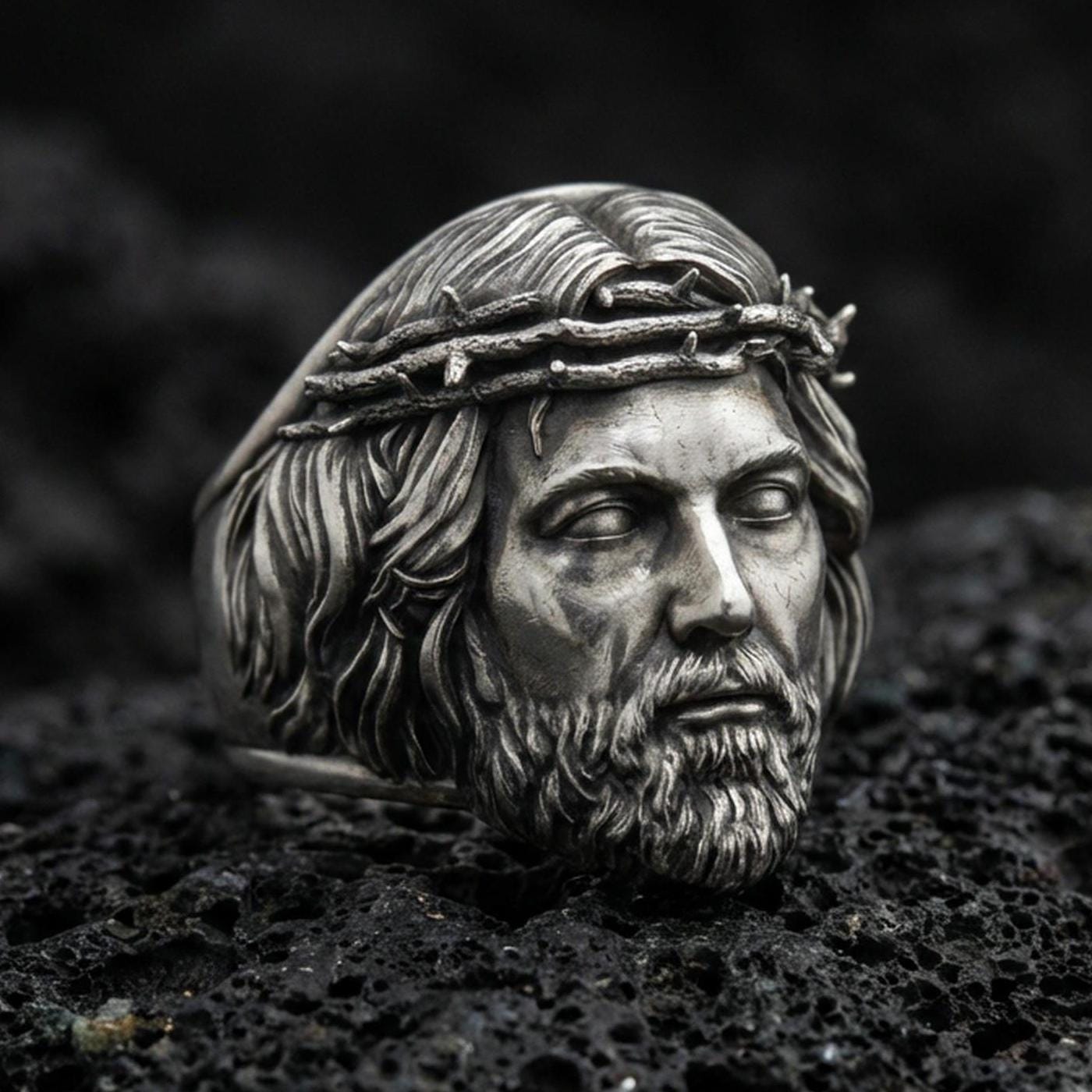 Oxidized 925 sterling silver Jesus head ring on volcanic rock, crown of thorns relief, realistic portrait statement jewelry