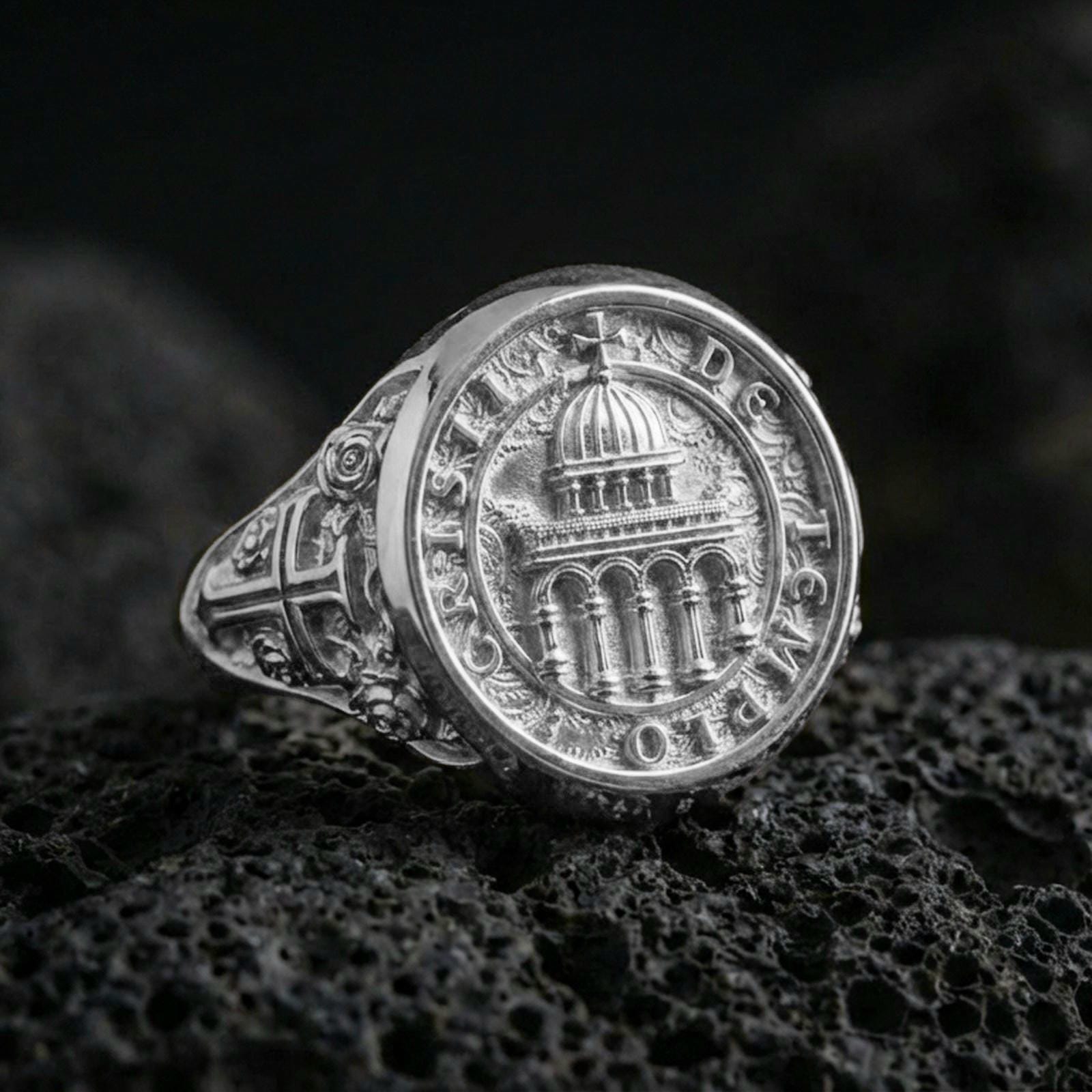 Polished silver Knights Templar seal signet ring on porous volcanic stone, cathedral dome emblem, detailed cross shoulder engraving
