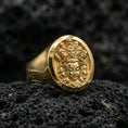 Load image into Gallery viewer, Gold plated multi-faced deity signet ring on dark volcanic rock, raised spiritual relief carving with ornate facial details
