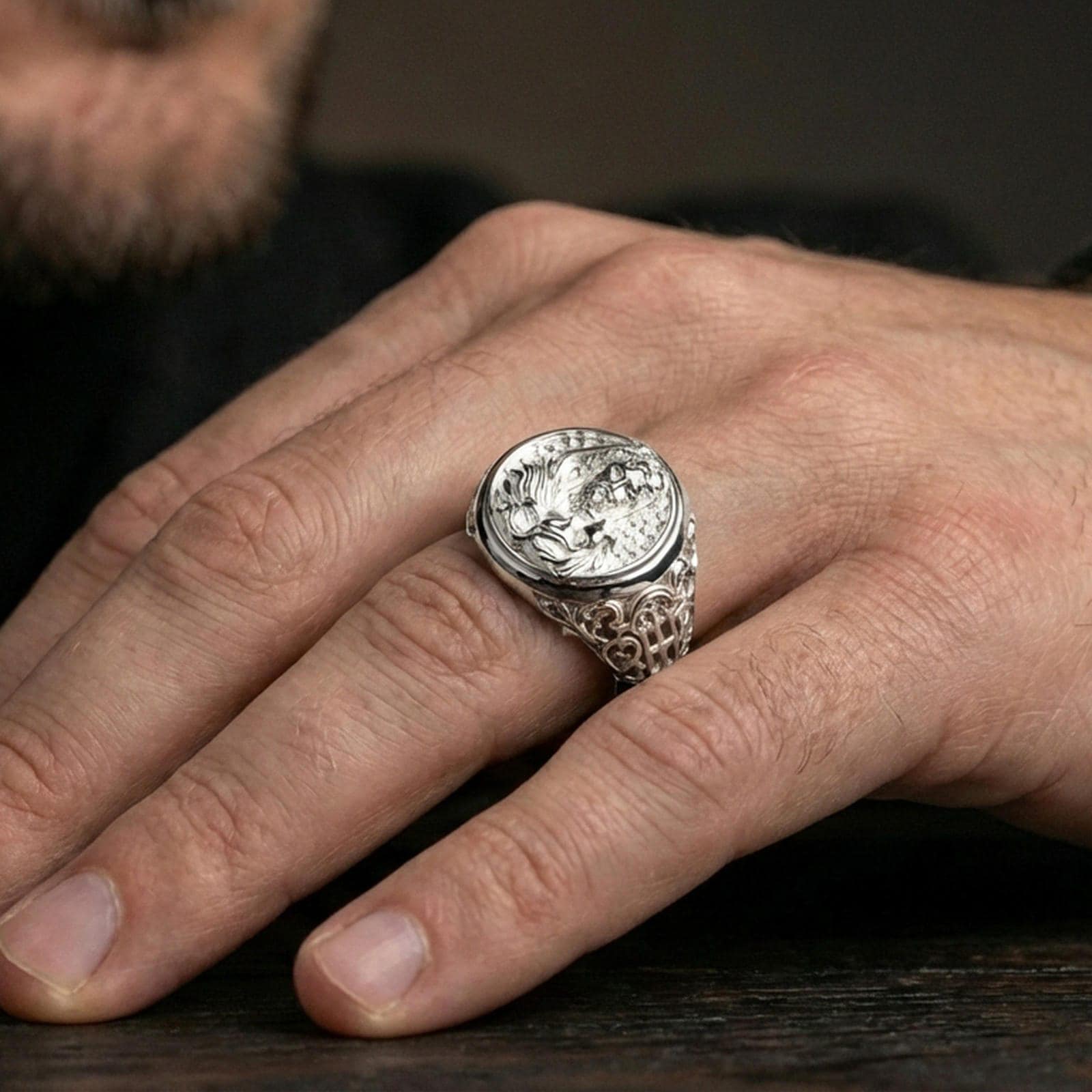Polished silver Good Shepherd signet ring worn on finger, oval Jesus and lamb engraving with clean shine and bold signet profile