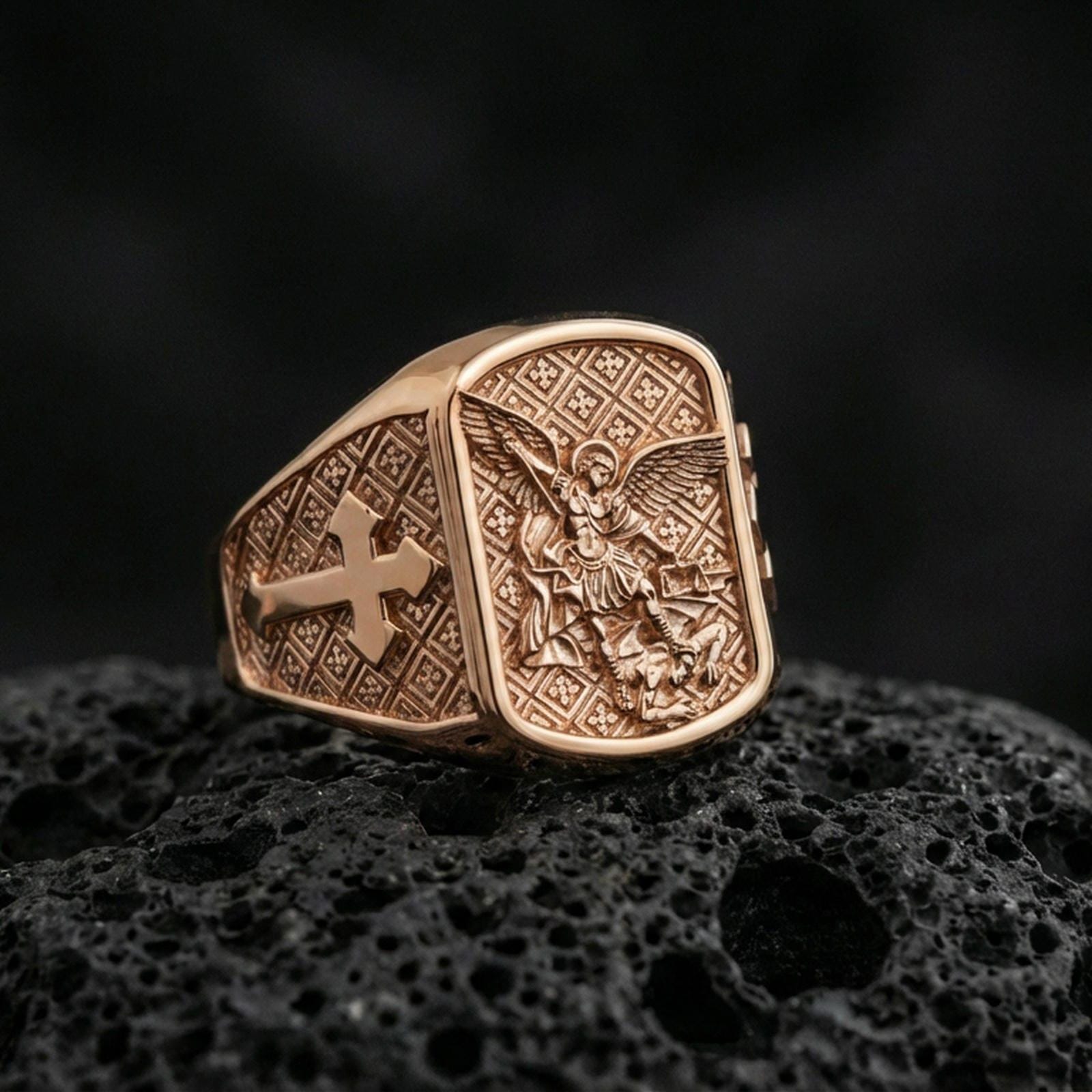 Rose gold plated Archangel Michael signet ring on volcanic stone, angel warrior relief with premium warm-tone finish