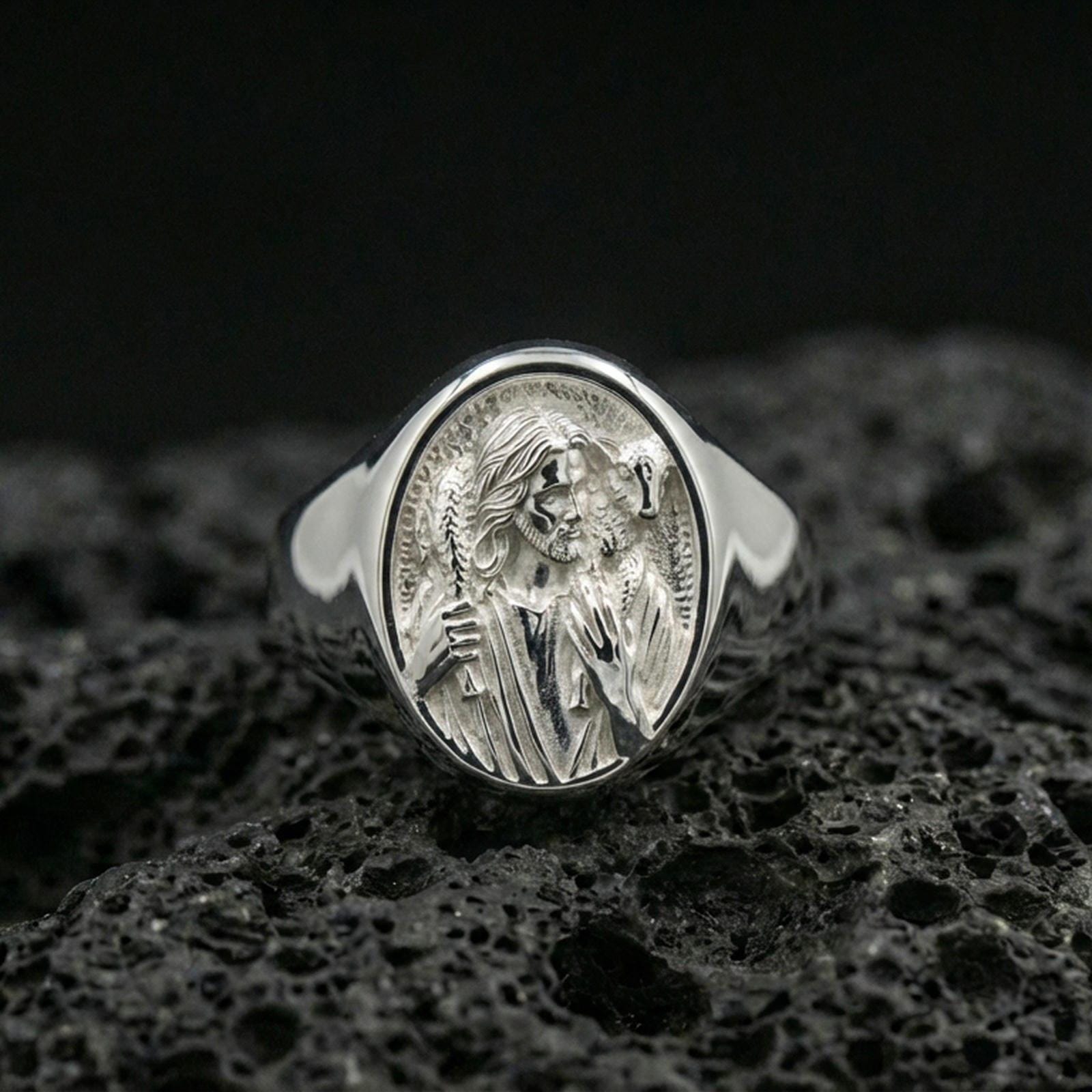 Polished silver Good Shepherd ring on porous volcanic stone, Jesus portrait with lamb over shoulders signet design