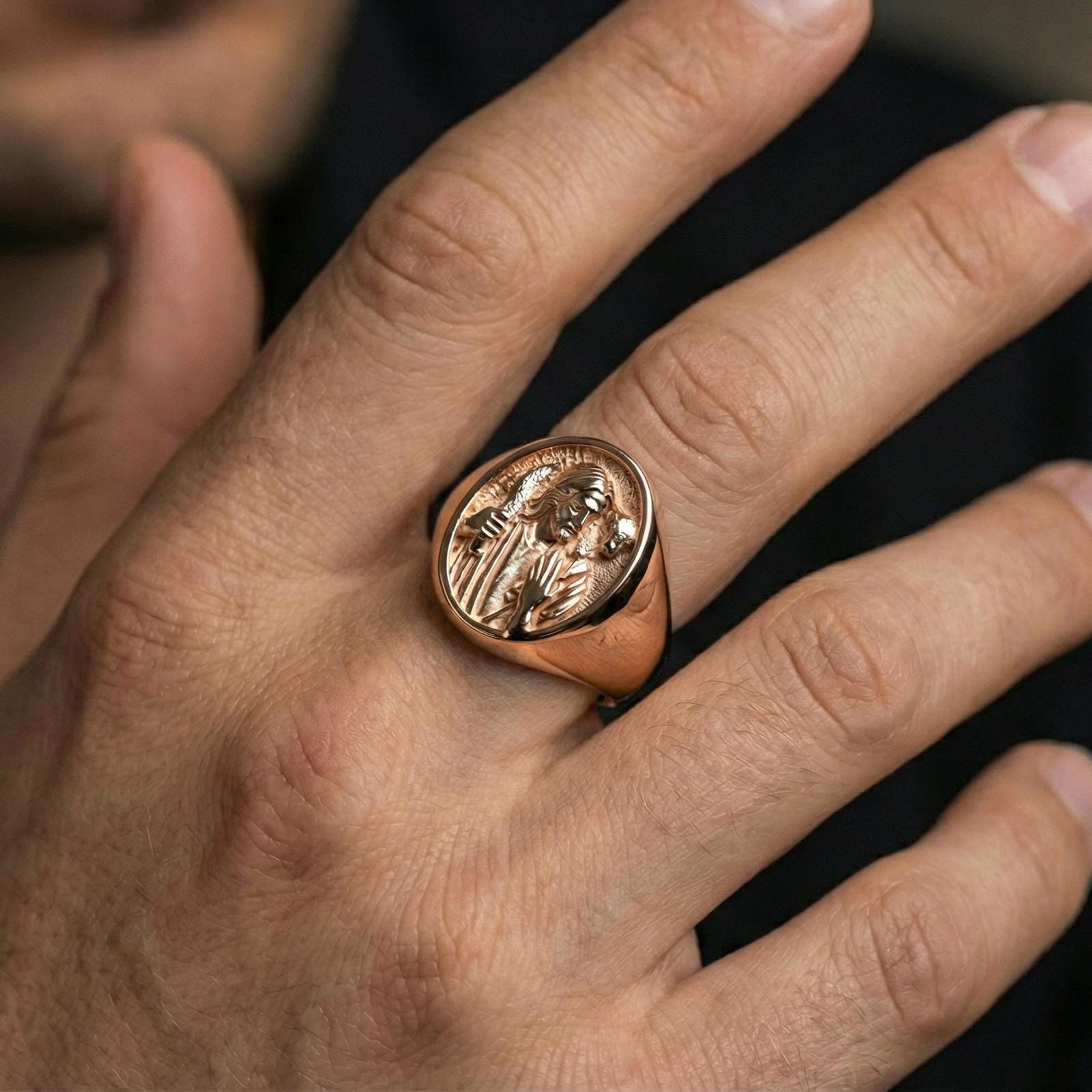 Rose gold plated Good Shepherd signet ring worn on finger, Jesus carrying lamb relief with smooth border bezel