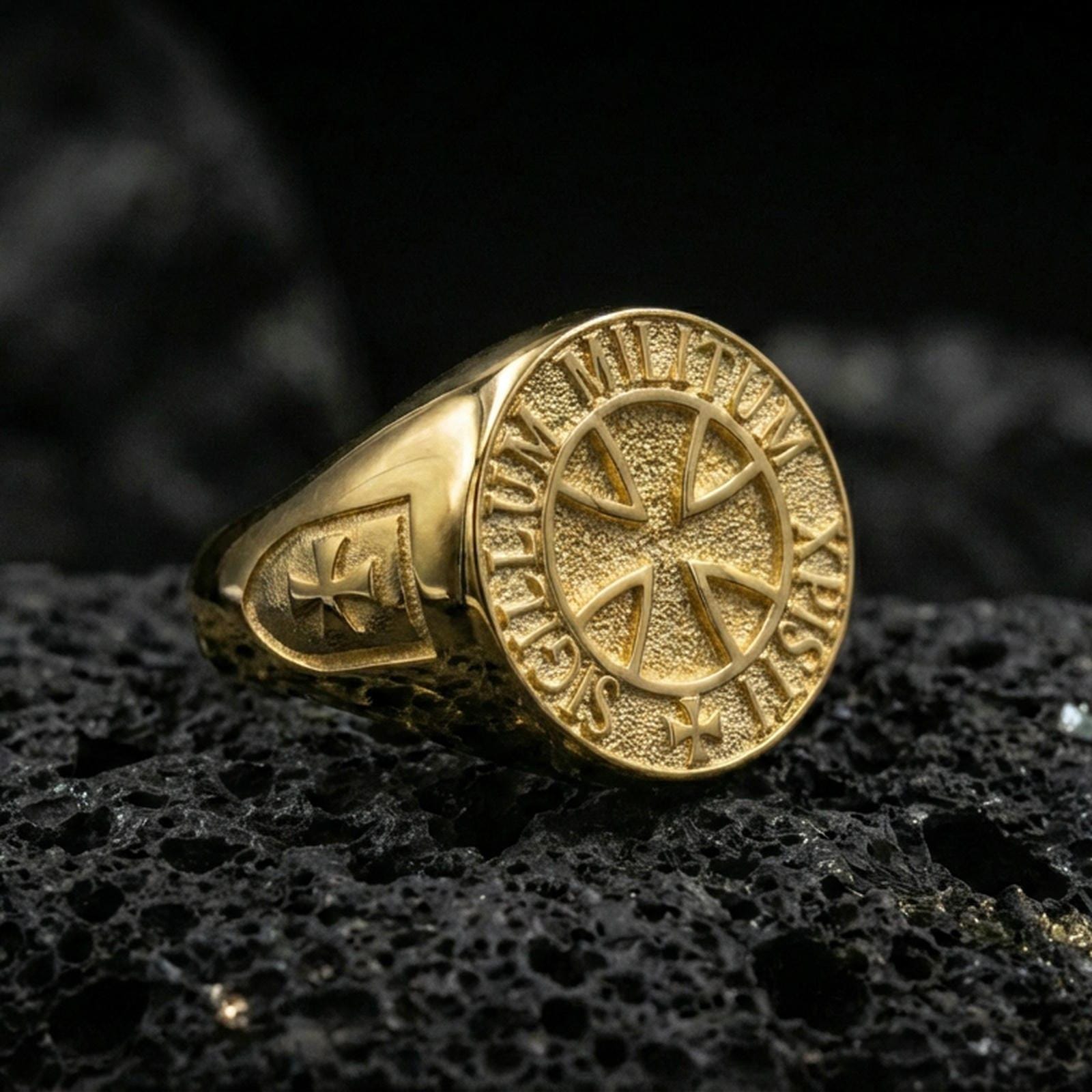 Gold plated Knights Templar signet ring on dark volcanic rock, Sigillum Militum Xpisti round seal cross