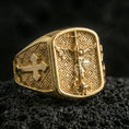 Load image into Gallery viewer, Gold plated Saint Michael ring on dark volcanic rock, archangel Michael slaying dragon with cross band detail
