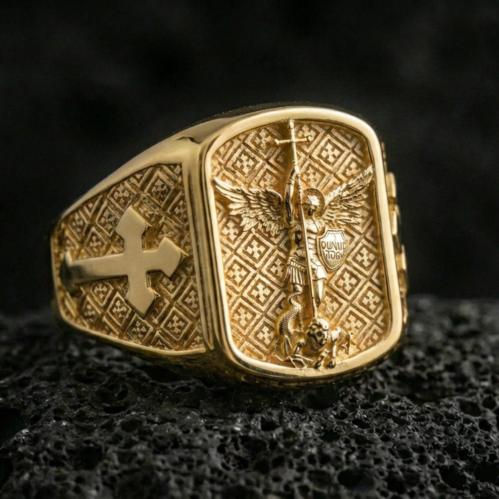 Gold plated Saint Michael ring on dark volcanic rock, archangel Michael slaying dragon with cross band detail