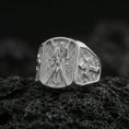 Load image into Gallery viewer, Polished silver Saint Andrew signet ring on porous volcanic stone, detailed saint relief with cross side design
