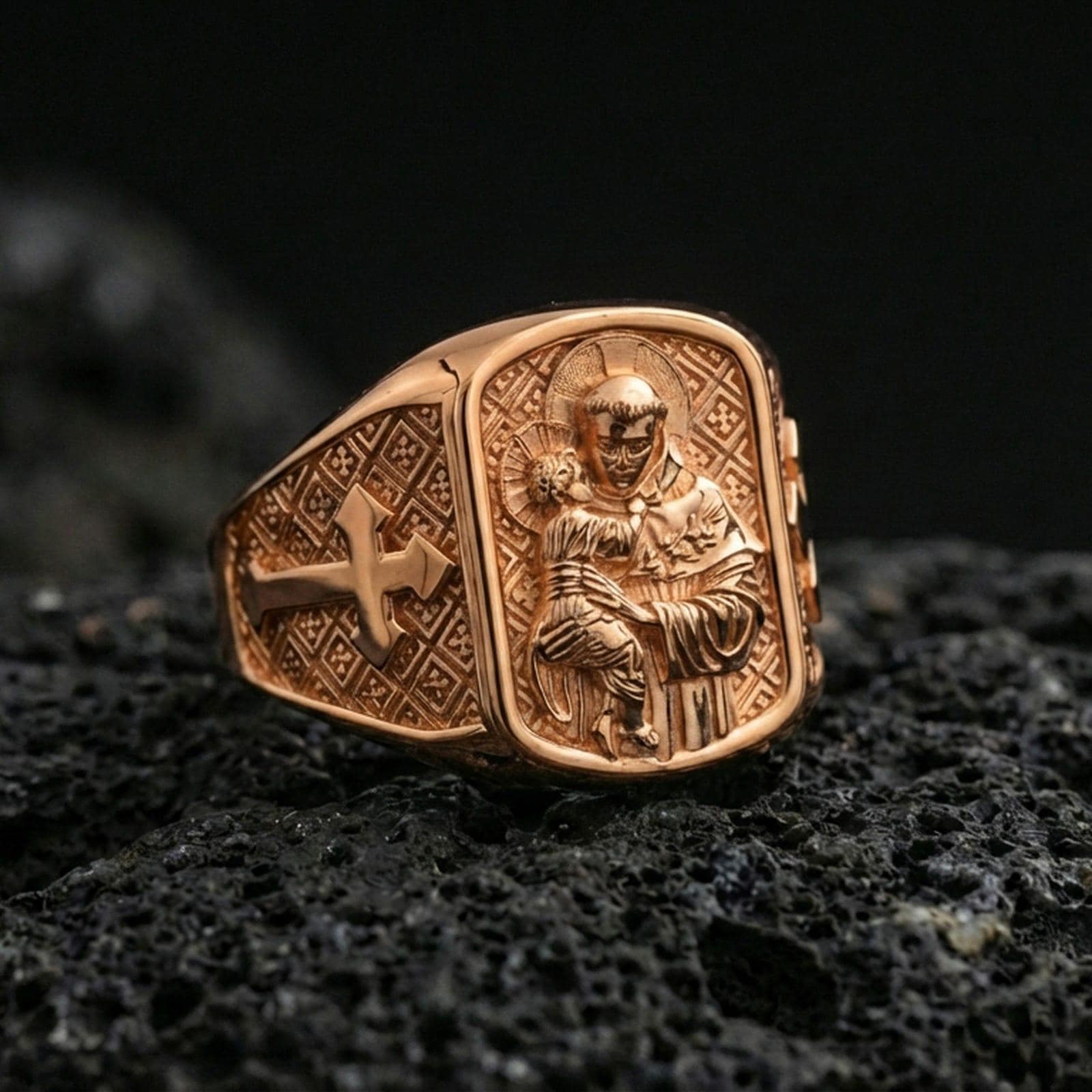 Rose gold plated Saint Anthony signet ring on dark volcanic stone, saint and Child Jesus engraving with cross side panel