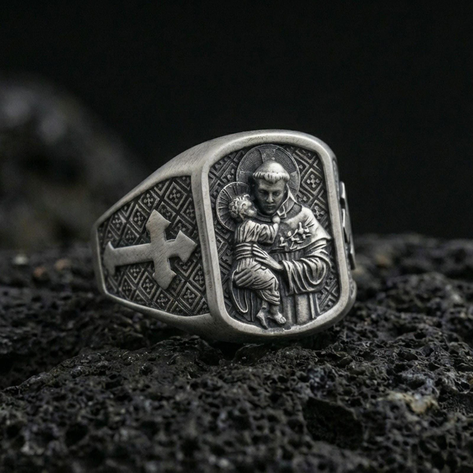Oxidized 925 sterling silver Saint Anthony ring on volcanic rock, saint holding Child Jesus relief with cross side panel