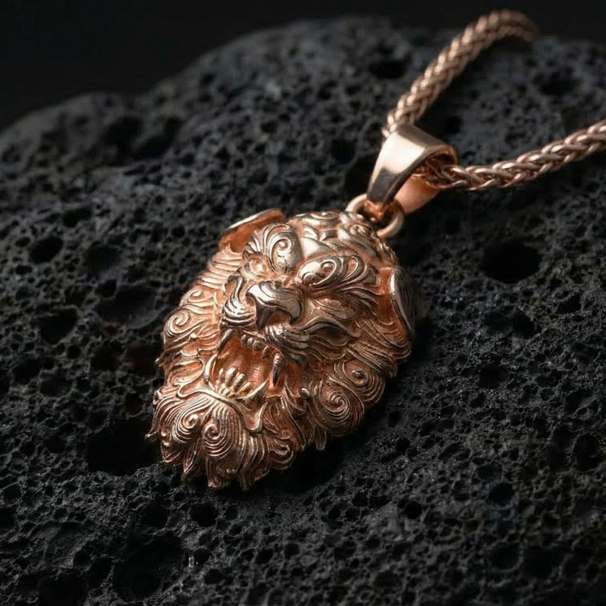 Rose gold plated Chinese Fu Dog pendant necklace presented on volcanic rock surface with refined oriental guardian style