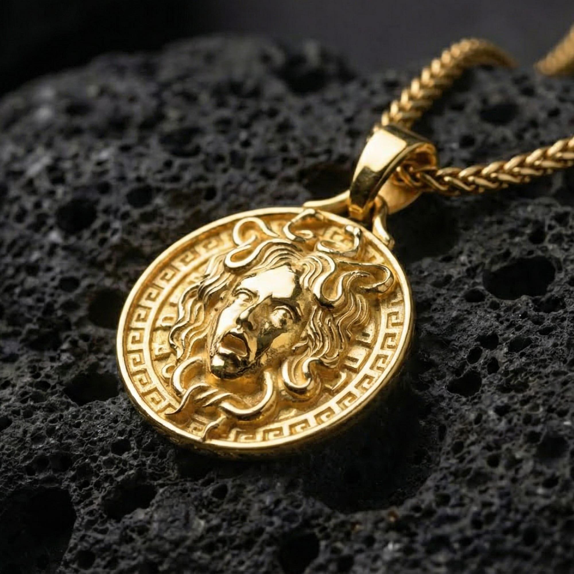 Gold plated Medusa pendant necklace showcased on volcanic rock as a symbol of power, protection, and transformation