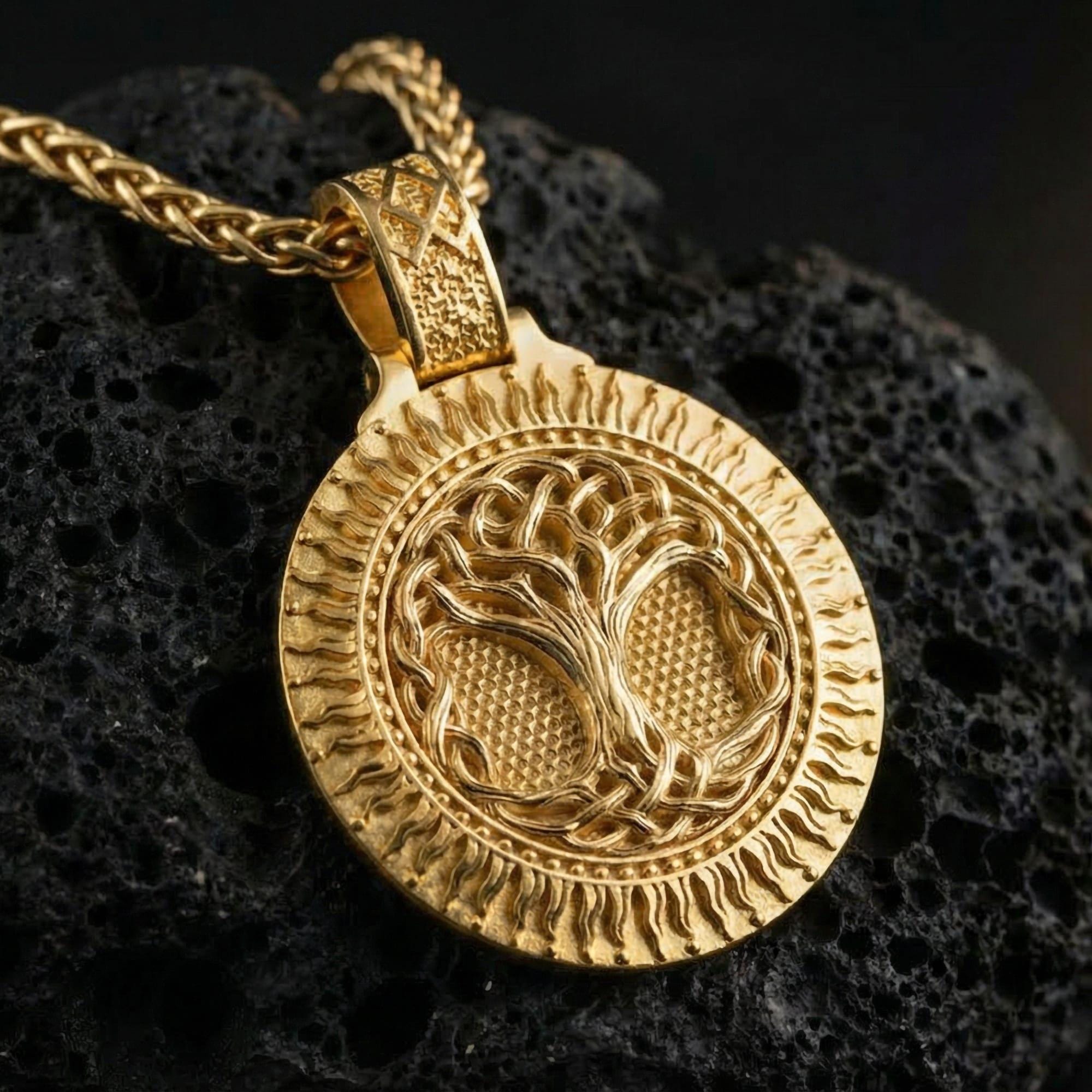 Gold plated Yggdrasil tree of life pendant showcased on volcanic rock as a symbol of balance, wisdom, and cosmic order