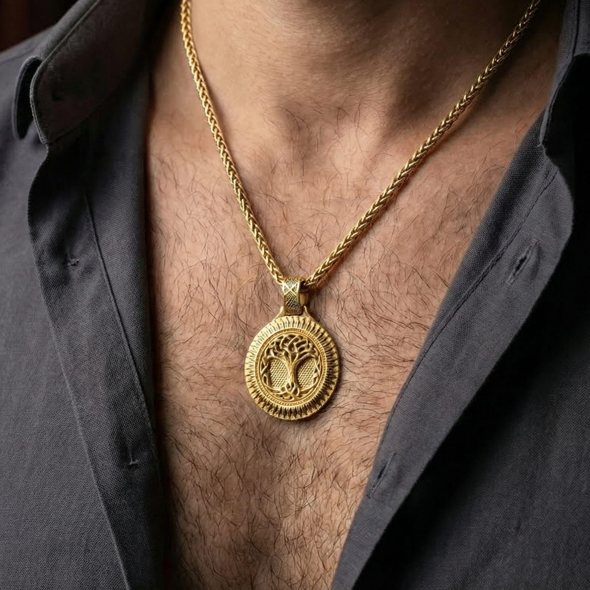 Gold plated tree of life Yggdrasil pendant necklace worn by man as meaningful mythological statement jewelry