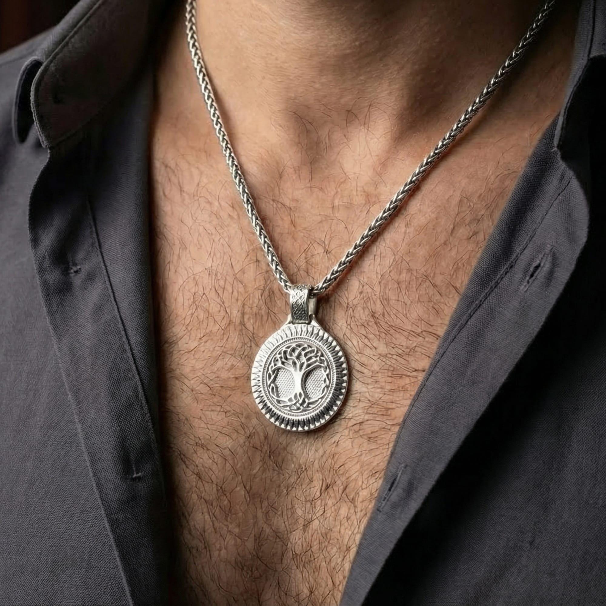 Polished silver Yggdrasil amulet worn on chest highlighting Viking mythology and interconnected worlds