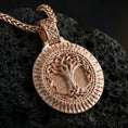 Load image into Gallery viewer, Rose gold plated Norse Yggdrasil pendant necklace presented on volcanic rock surface with refined mythological aesthetic
