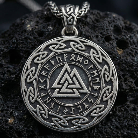 Oxidized Valknut rune pendant necklace photographed on volcanic rock with engraved Norse runes and interlocked triangle symbol