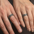 Load image into Gallery viewer, Oxidized Celtic trinity knot band ring worn on finger of a woman and man as a symbolic jewelry
