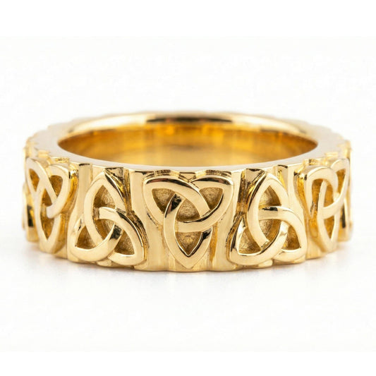 Gold Celtic trinity knot band ring displayed on white surface as symbolic jewelry