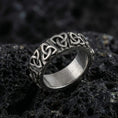 Load image into Gallery viewer, Oxidized sterling silver Celtic trinity knot band ring photographed on volcanic rock background
