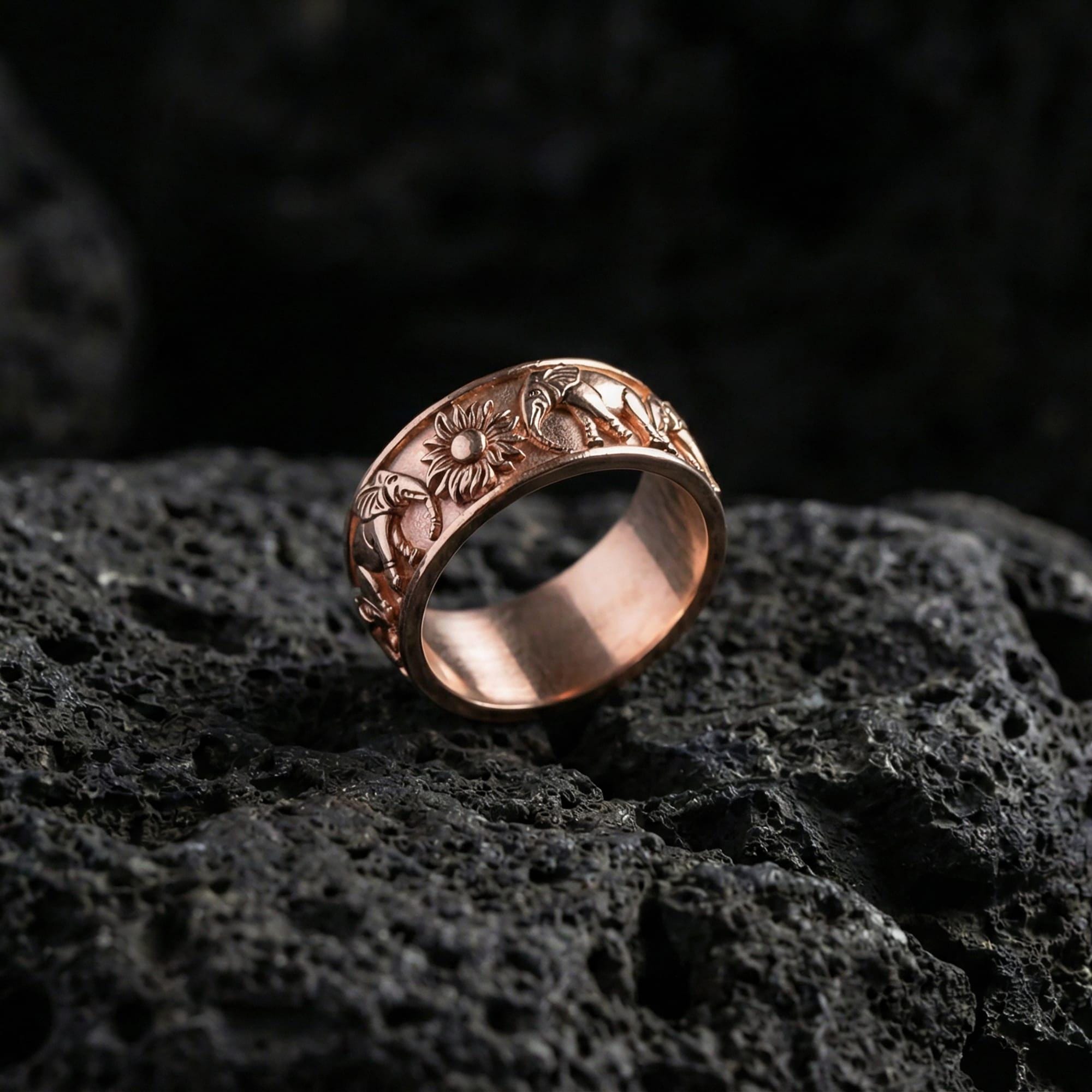 Rose gold plated faceted texture ring presented on volcanic rock surface with premium sculpted prism detailing and sleek minimalist style
