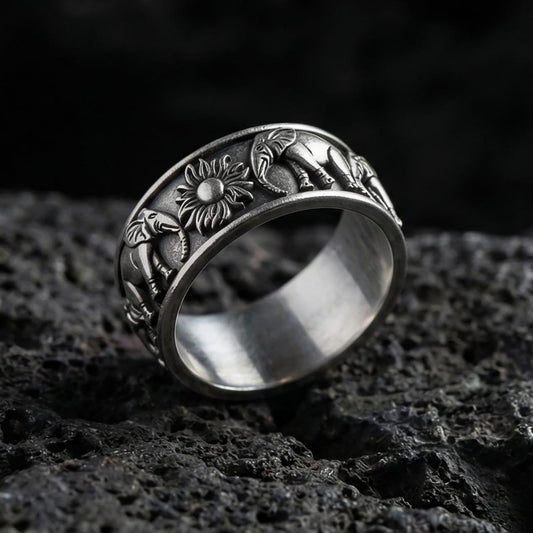 Oxidized geometric faceted band ring photographed on volcanic rock with sharp pyramid-cut texture and industrial masculine finish
